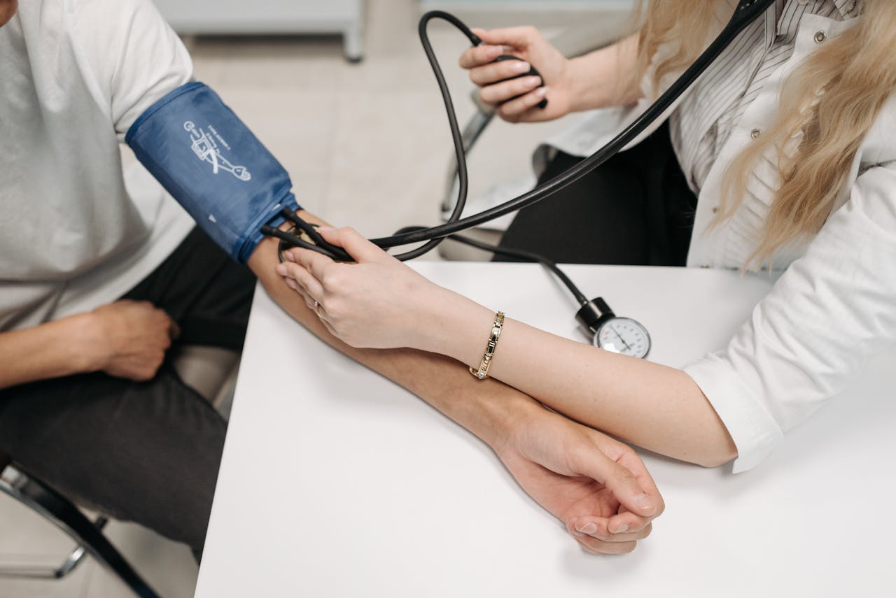 A doctor measures a patient's blood pressure with a sphygmomanometer during a consultation.